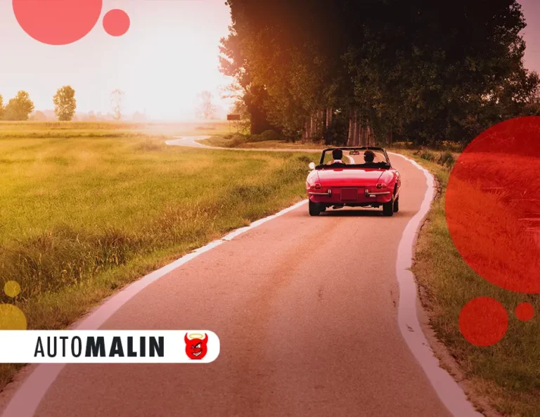 Route de campagne sur laquelle figure une voiture rouge cabriolet avec deux personnes à l'intérieur