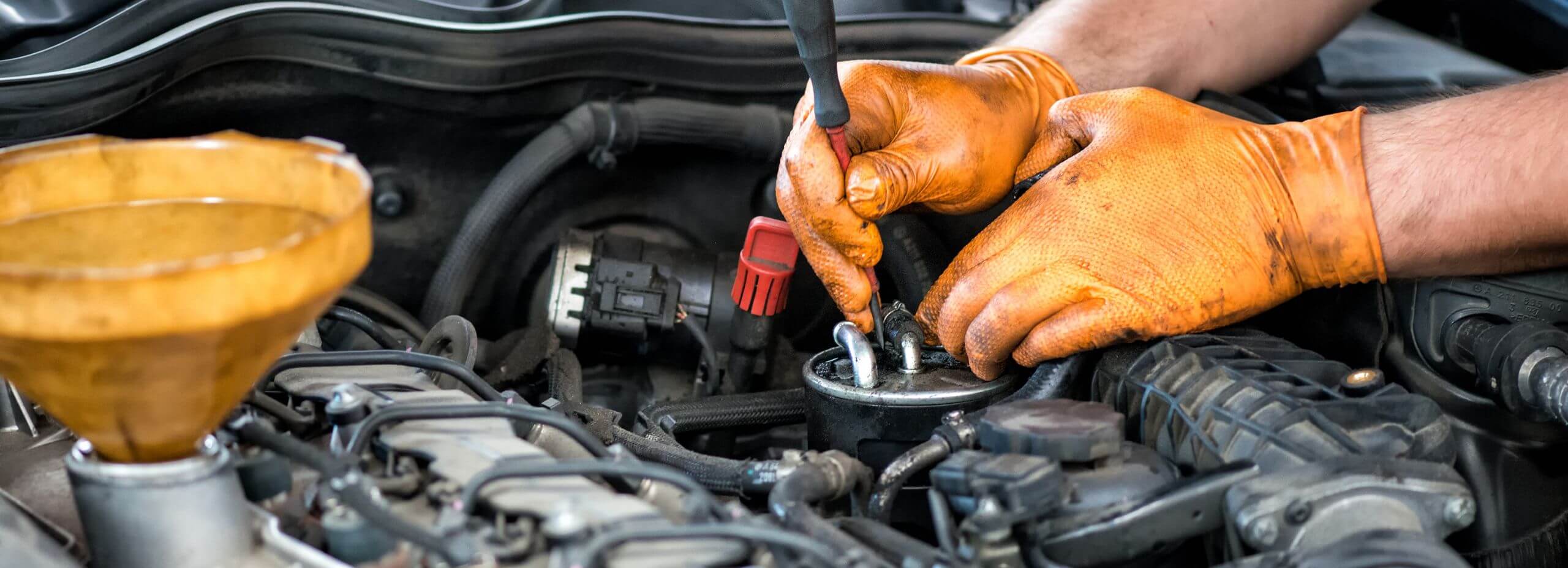 Mécanicien effectuant l'entretien d'une voiture hybride avec contrôle du moteur et remplacement de pièces