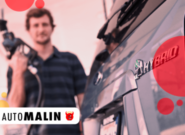Voiture hybride en plein ravitaillement avec logo HYBRID, représentant l’entretien et l’utilisation d’un véhicule hybride chez AutoMalin en 2025