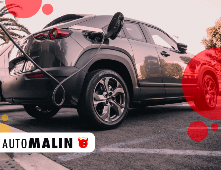 Voiture électrique grise en train de se recharger sur une borne dans un parking