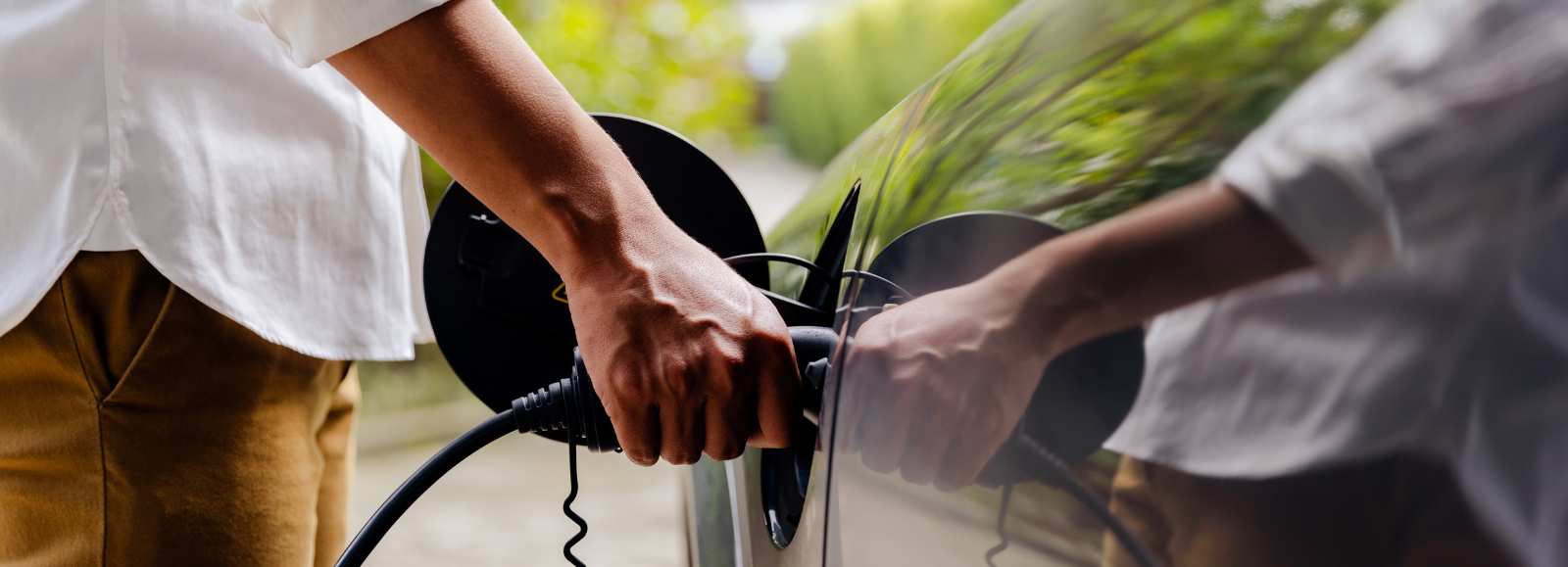 Recharge d'une voiture électrique à domicile à l'aide d'un câble branché sur une borne.