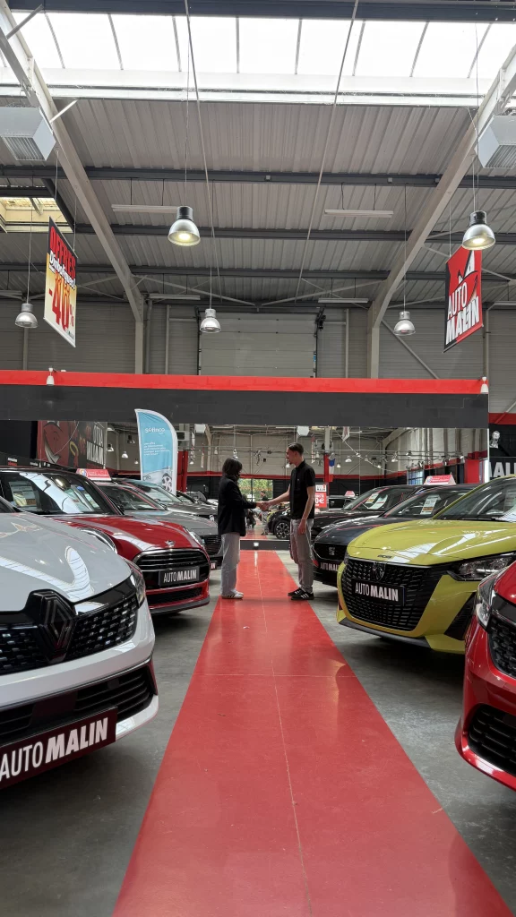 Un conseiller Automalin accueille une cliente dans le showroom de voitures d'occasion en Gironde